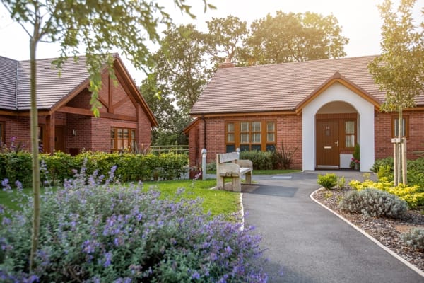Exterior view of a senior living facility with gardens