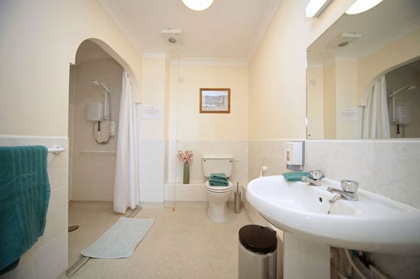 Well-lit bathroom with shower and sink