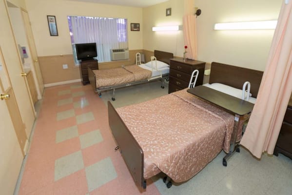 A shared resident room with two beds and basic furnishings