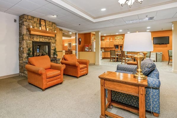 Lounge seating with orange chairs and fireplace