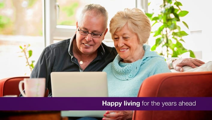 Two seniors enjoying time together with a laptop