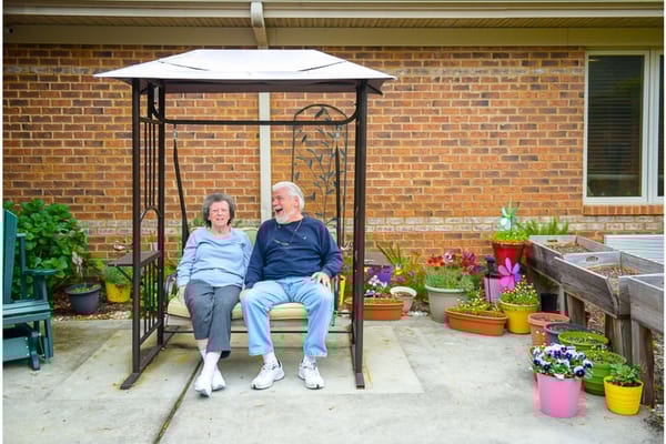 Couple enjoying a swing in a garden area