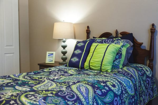 Cozy bedroom featuring a colorful bedspread and lamp