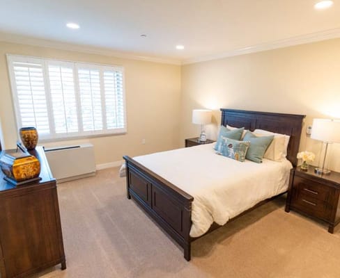 Brightly lit private resident room with a bed and furniture