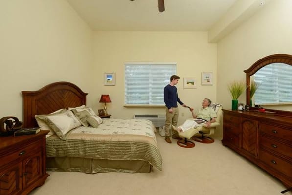 Comfortable resident room with a caregiver and elder