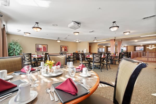Dining room set with tables, flowers, and utensils