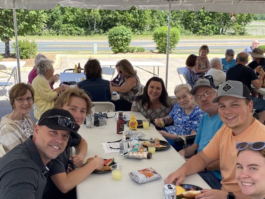 Residents and staff enjoying a meal at an outdoor event