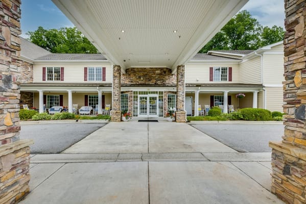 Main entrance of Arbor Ridge at Kernersville with rocking chairs and flower pots