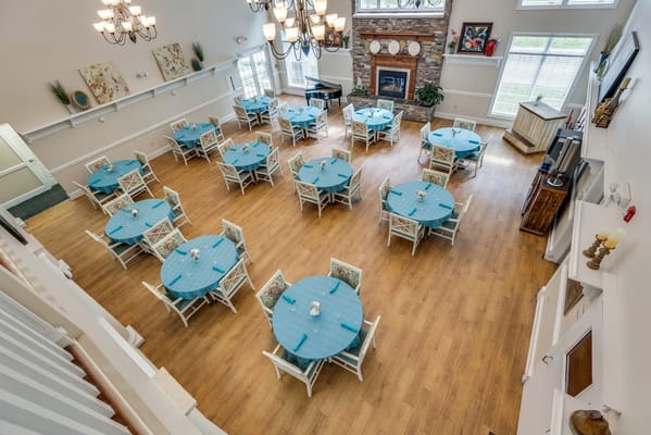 Overview of a dining room with circular tables and blue table covers