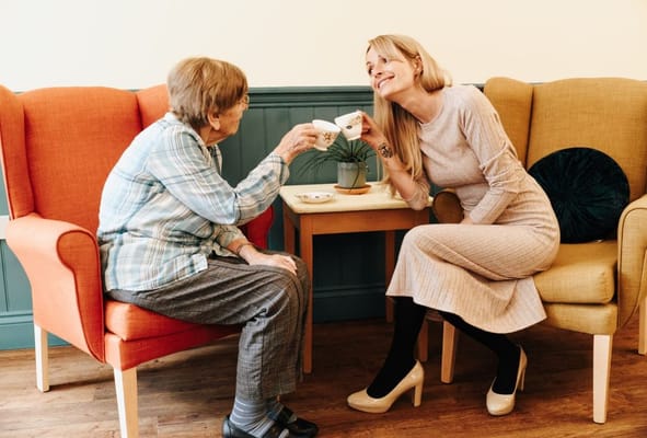 A resident and staff member enjoying tea together