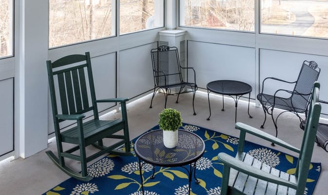 Comfortable chairs and a table in a sunlit sunroom