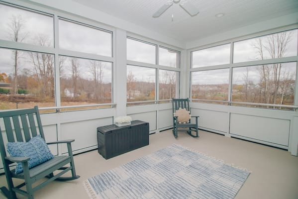 Bright sunroom with rocking chairs and a view