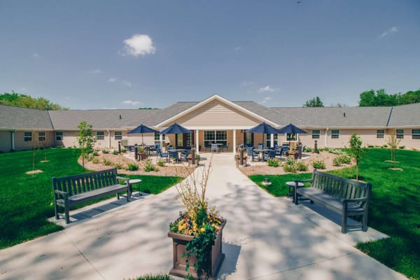 Exterior view of a senior living facility with gardens
