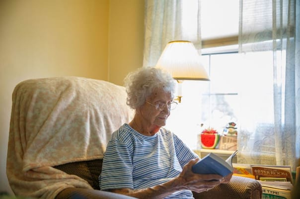 Senior woman reading in a cozy chair by the window