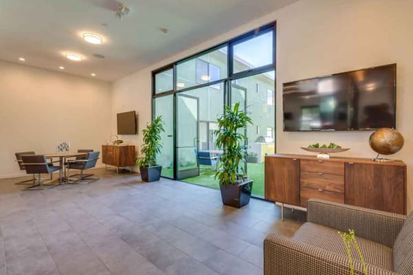 Bright common area with large windows and seating