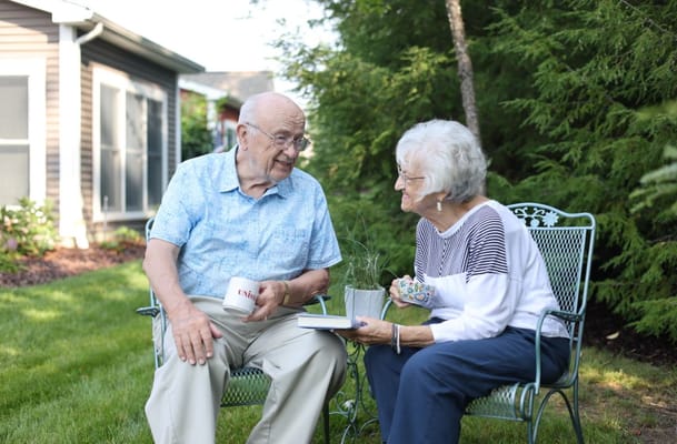 Two seniors enjoying a conversation in a garden