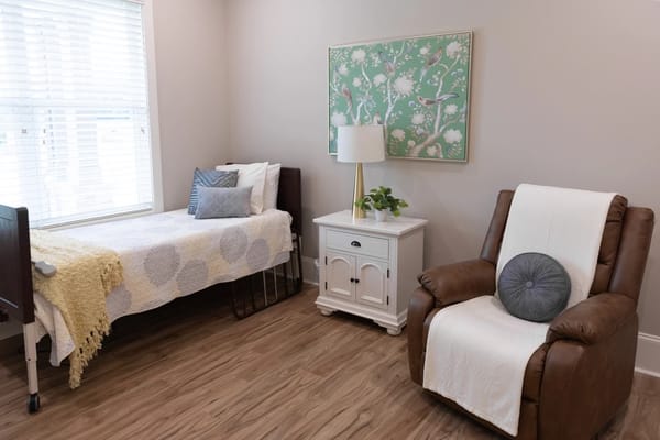 Cozy resident room with a bed and recliner chair