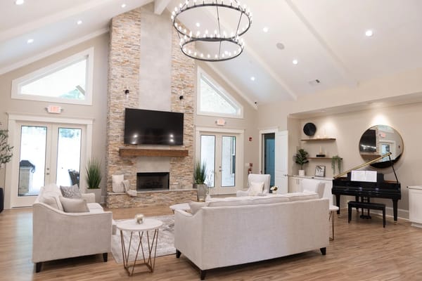 Bright and spacious common area with seating and piano
