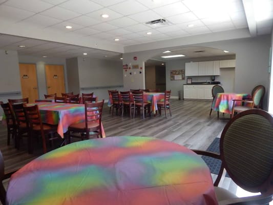Dining area with colorful tablecloths and chairs