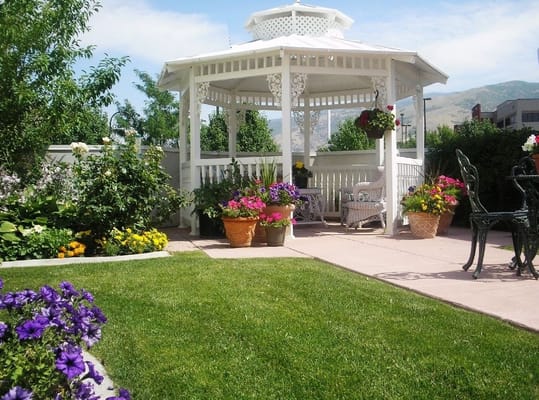 Beautiful outdoor gazebo surrounded by flowers and greenery