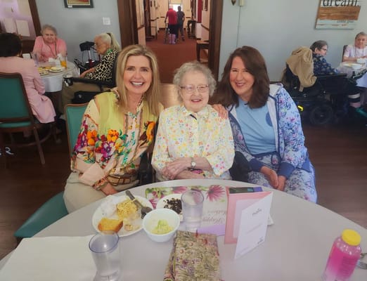 Residents enjoying a meal with staff in a dining area
