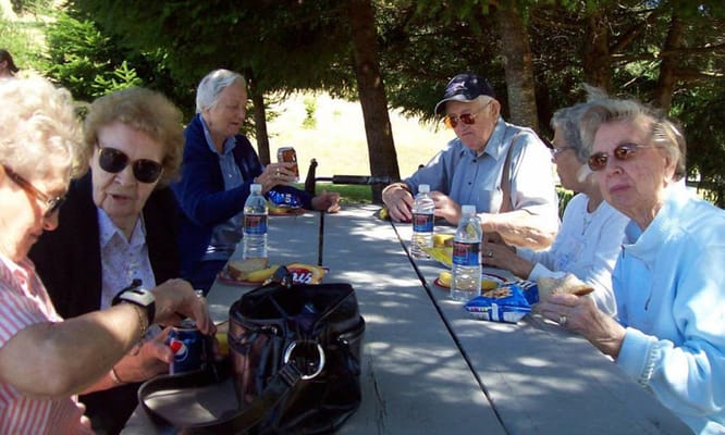 Residents enjoying snacks outdoors at a picnic table