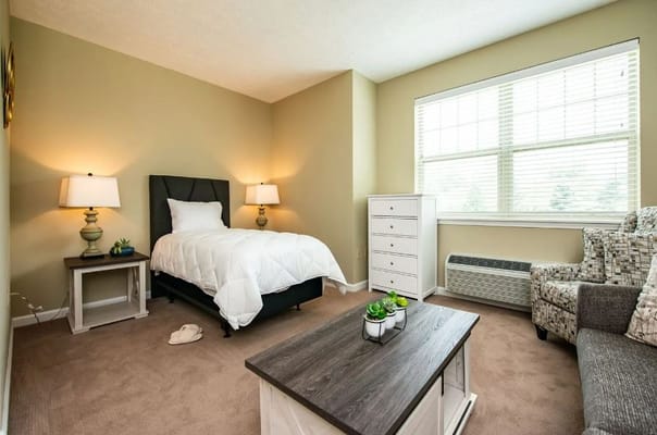 Cozy resident room with a single bed and seating area