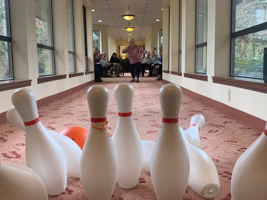 Residents bowling in a brightly lit corridor