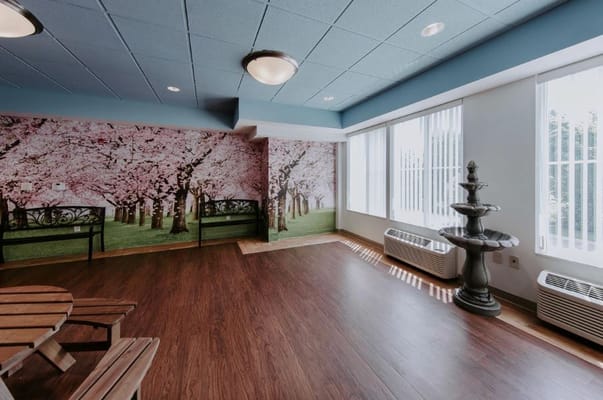 Bright common area with cherry blossom mural and seating