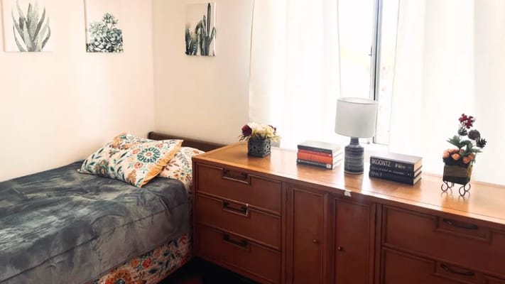 Cozy resident room with bed and dresser