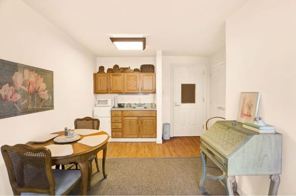 Cozy interior view of a resident room with a table and kitchenette