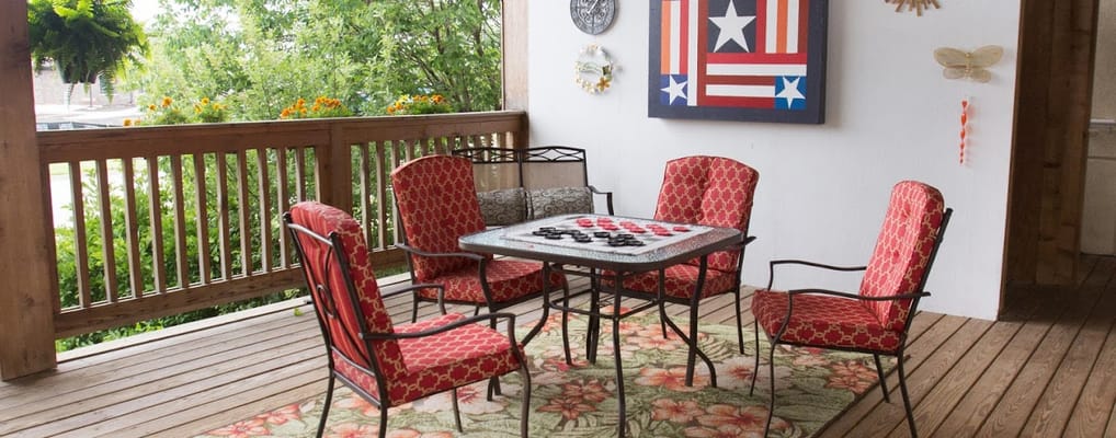 Outdoor seating area with red chairs and a game table