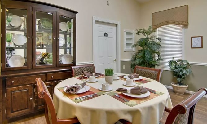 Cozy dining area with a round table set for meals, featuring a wooden cabinet.