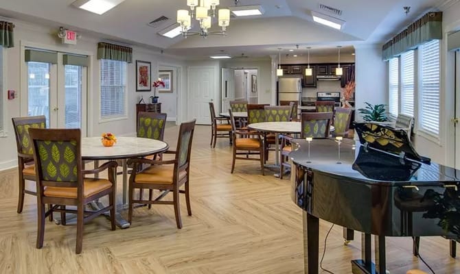 A spacious dining area with tables and a piano at Bradford Court.