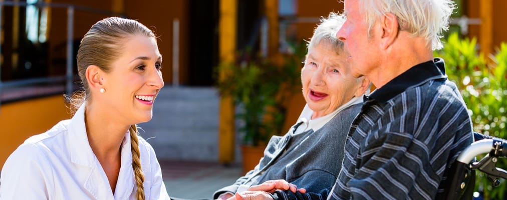 Caregiver interacting with residents outdoors