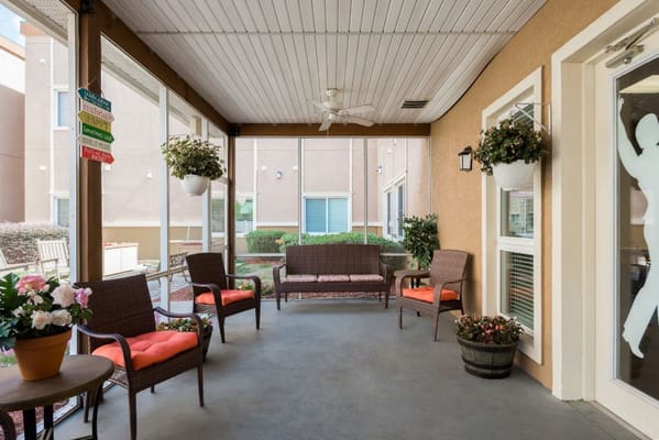 Outdoor patio with chairs, plants, and signs at Brentwood at Fore Ranch