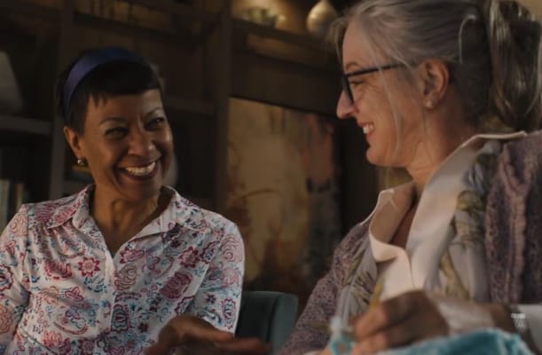 Two women enjoying a conversation in a cozy common area