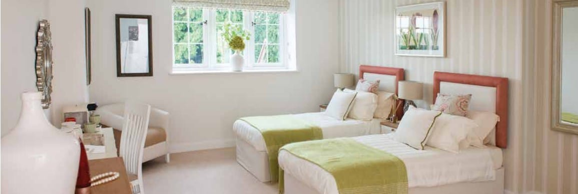 A beautifully decorated shared bedroom with two beds and a window view.