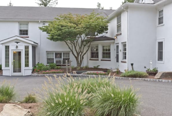Entrance of Bryan Manor with landscaping and a decorative tree.