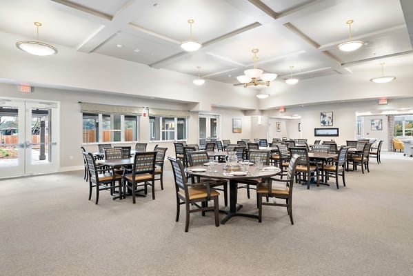 Spacious dining area with tables and chairs set for residents