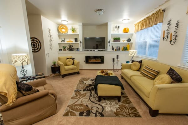Well-decorated living room with two yellow sofas and a TV