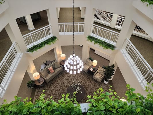 Aerial view of the lobby featuring a chandelier, seating area, and greenery.
