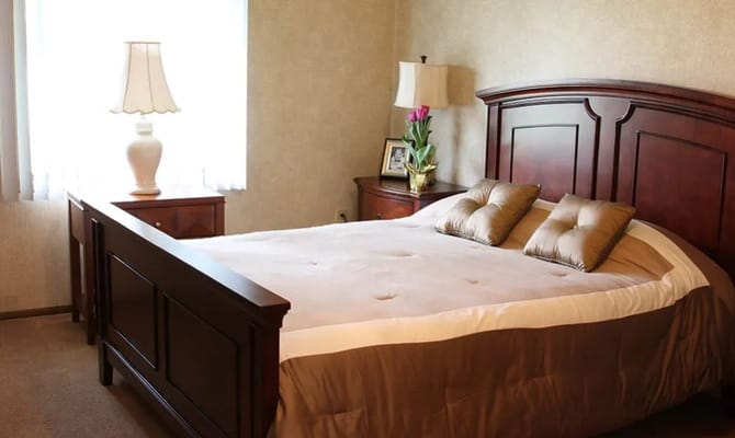 Cozy private resident room with a bed and bedside lamp