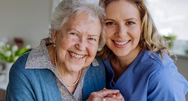 A caregiver and resident smiling together