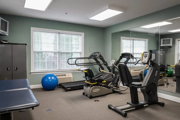 Interior view of the fitness center with exercise equipment and a blue exercise ball.