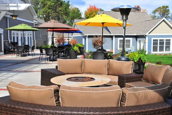 Outdoor seating area with colorful umbrellas and fire pit