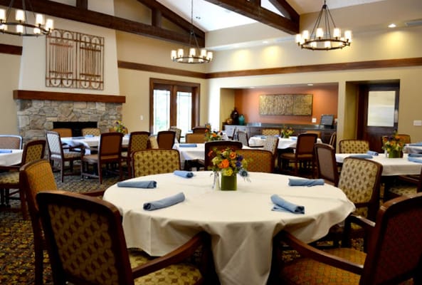 A dining room in the Cedars of Dexter facility with tables set