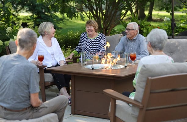 Residents enjoying drinks around a fire pit outdoors