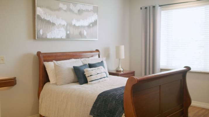 A well-decorated resident room with a bed and window