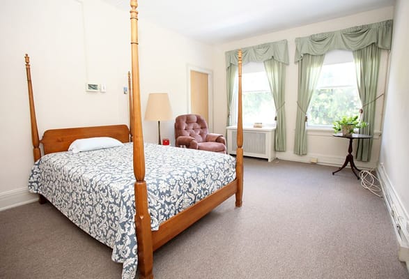 A private room with a wooden bed and chair